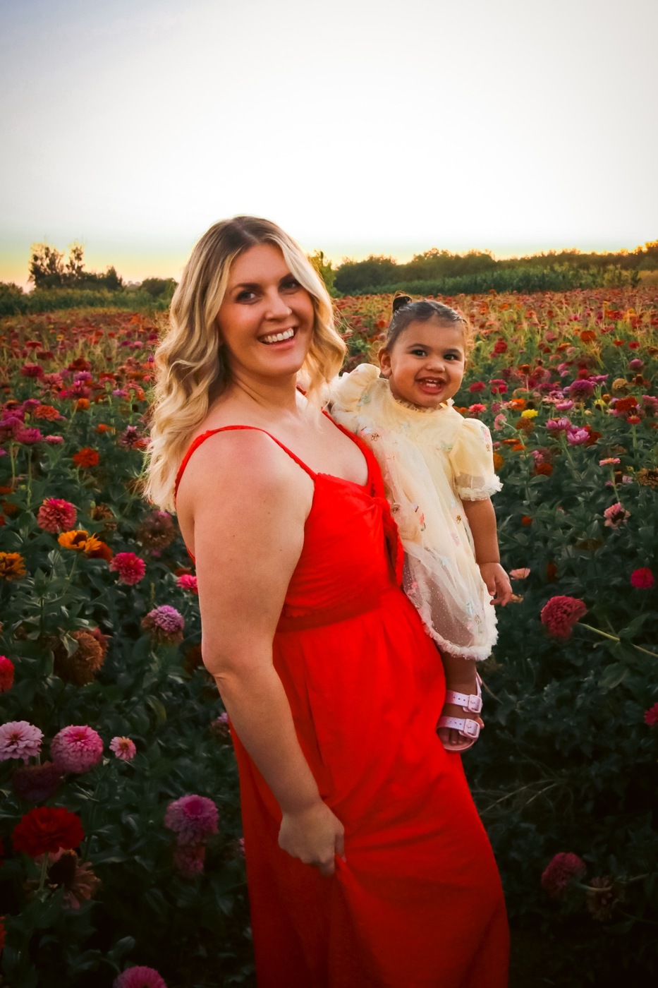 Lauren holding her daughter in a flower field