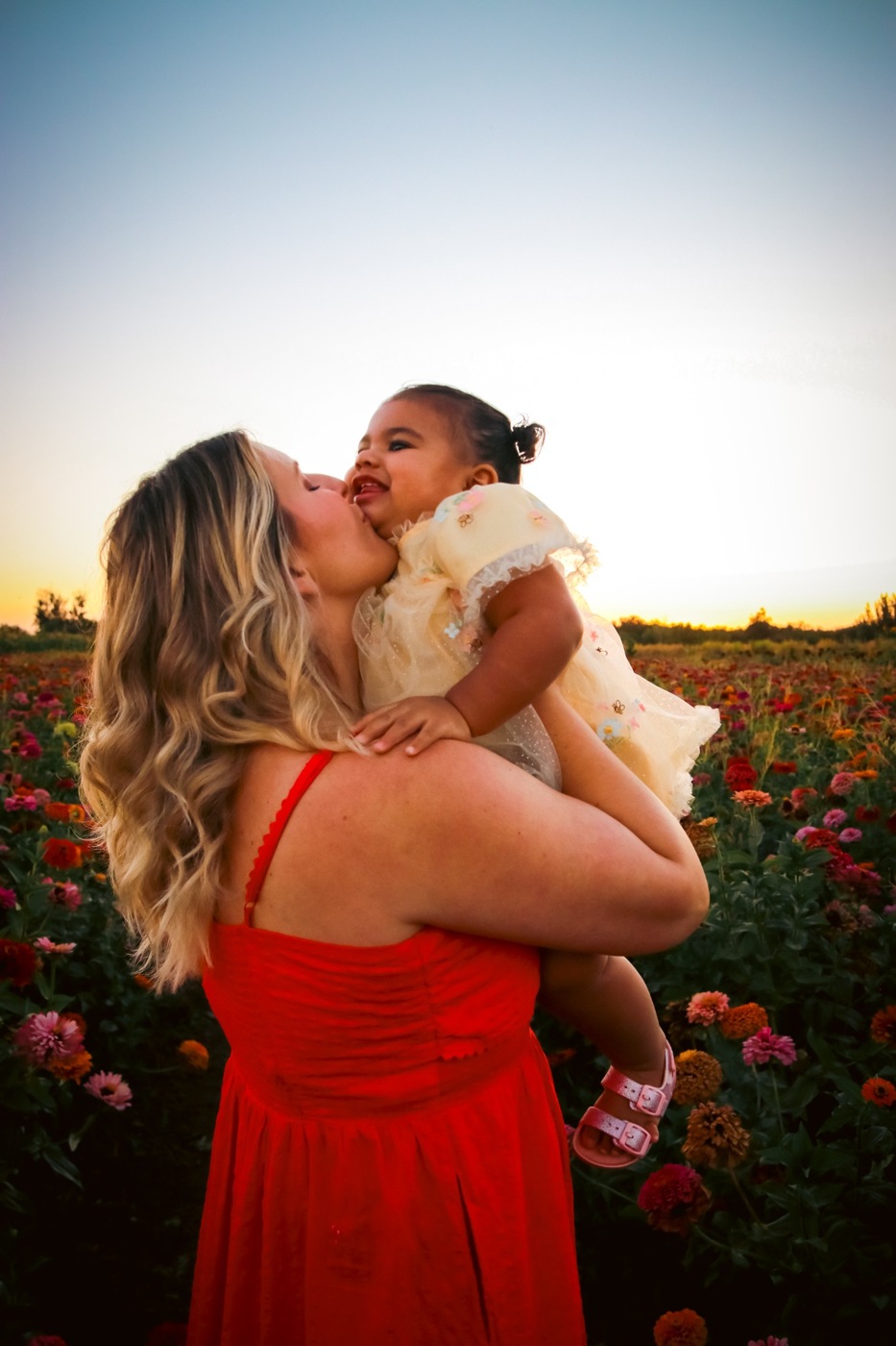 Lauren kissing her daughter in a flower field