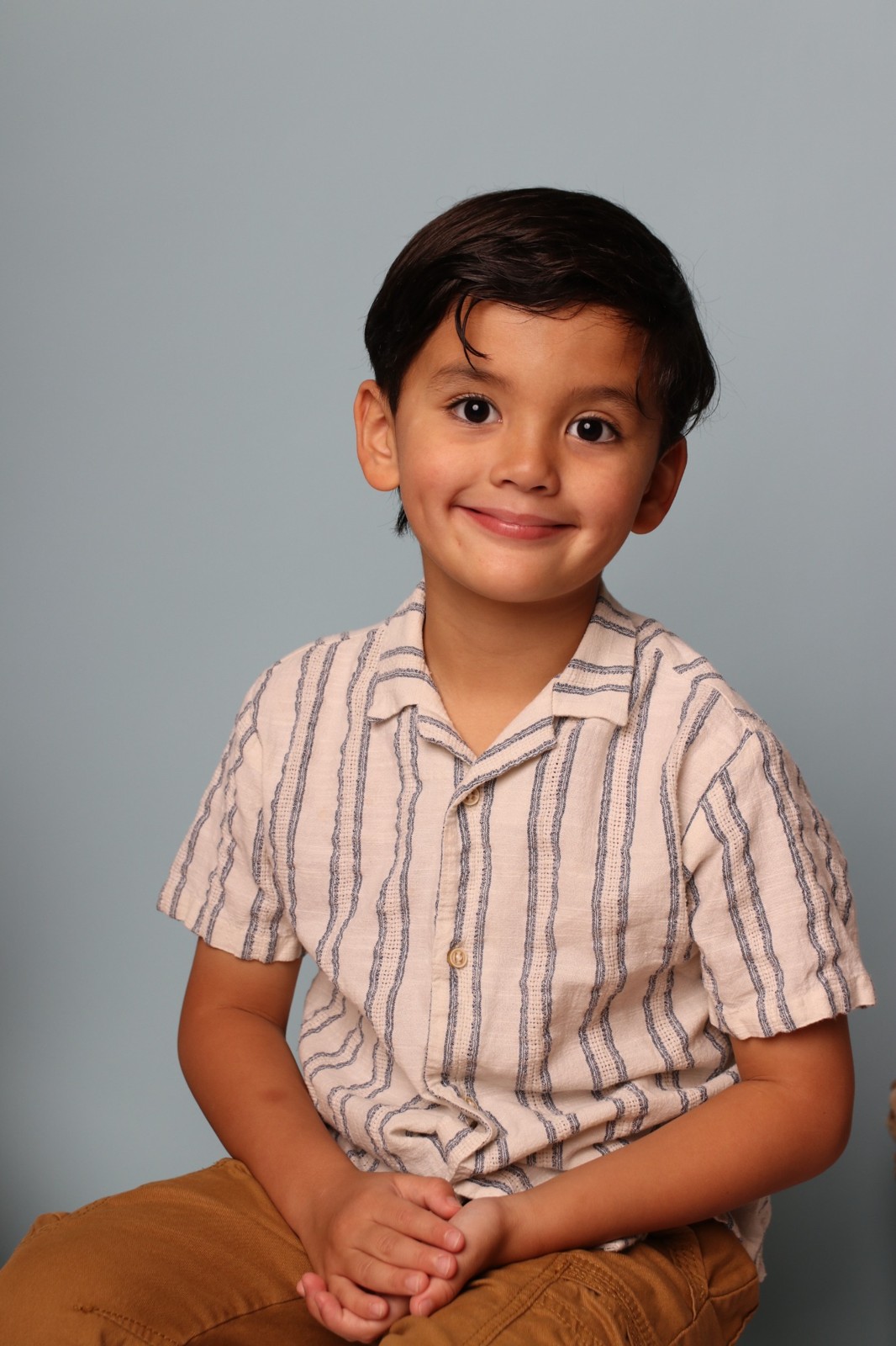 Studio school portrait against a blue backdrop