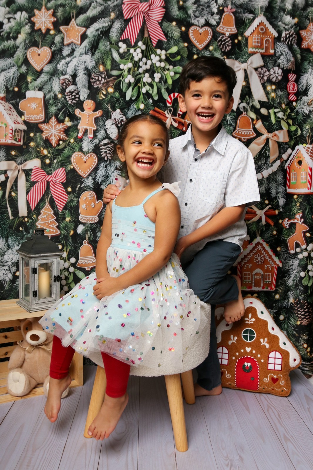 Sibling holiday portrait with a festive gingerbread backdrop